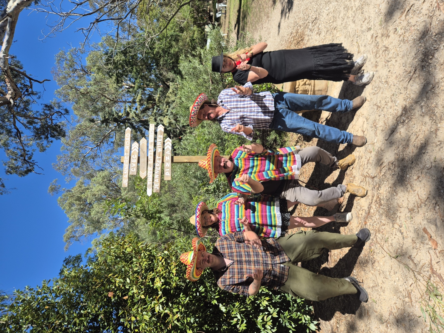 The Jeanneret Rd crew in sombreros beside the signpost pointing to CVBC, Three Little Birds, Jeanneret Wines and pizza